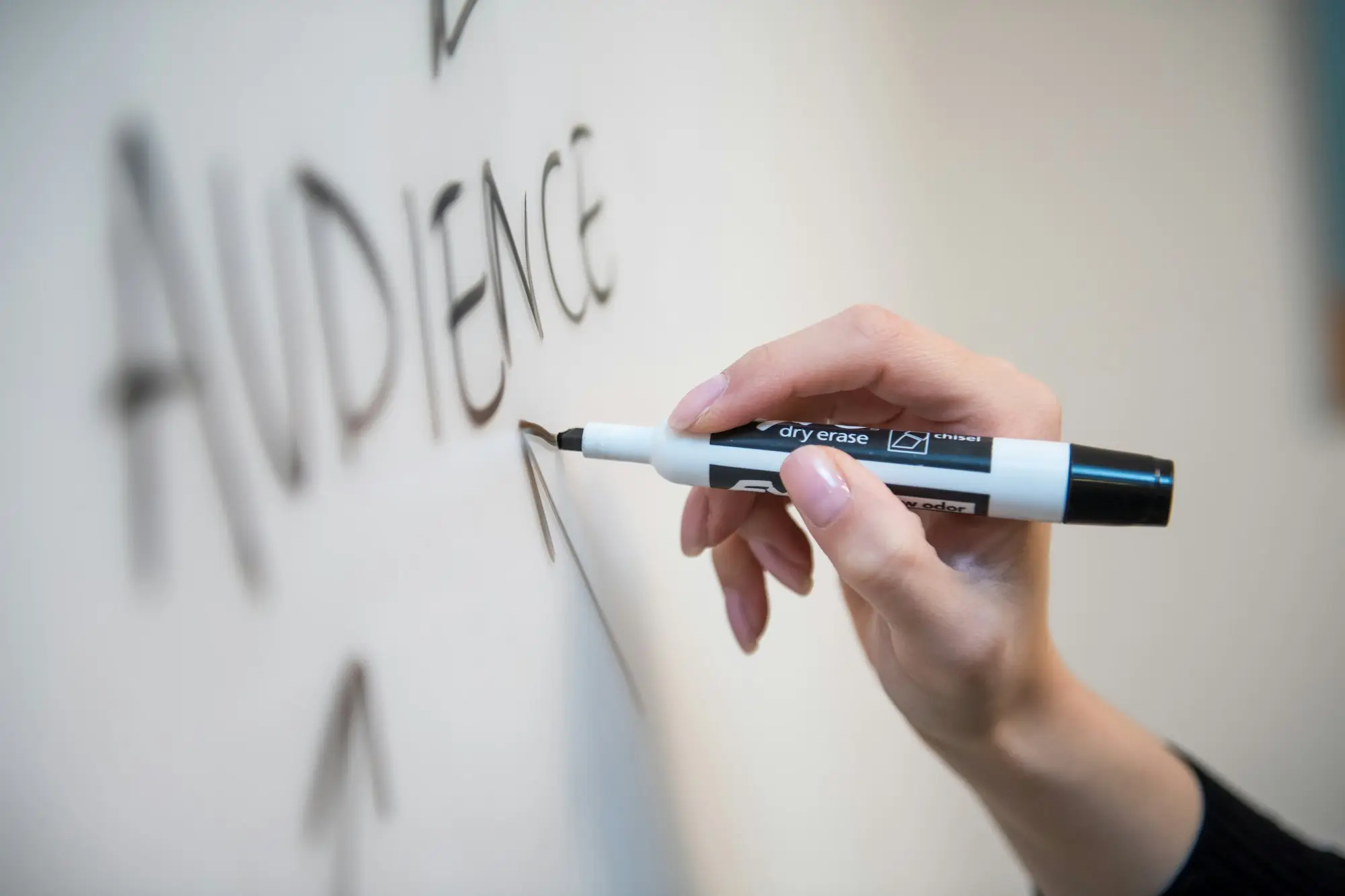 Business owner writing on a whiteboard while weighing a decision
