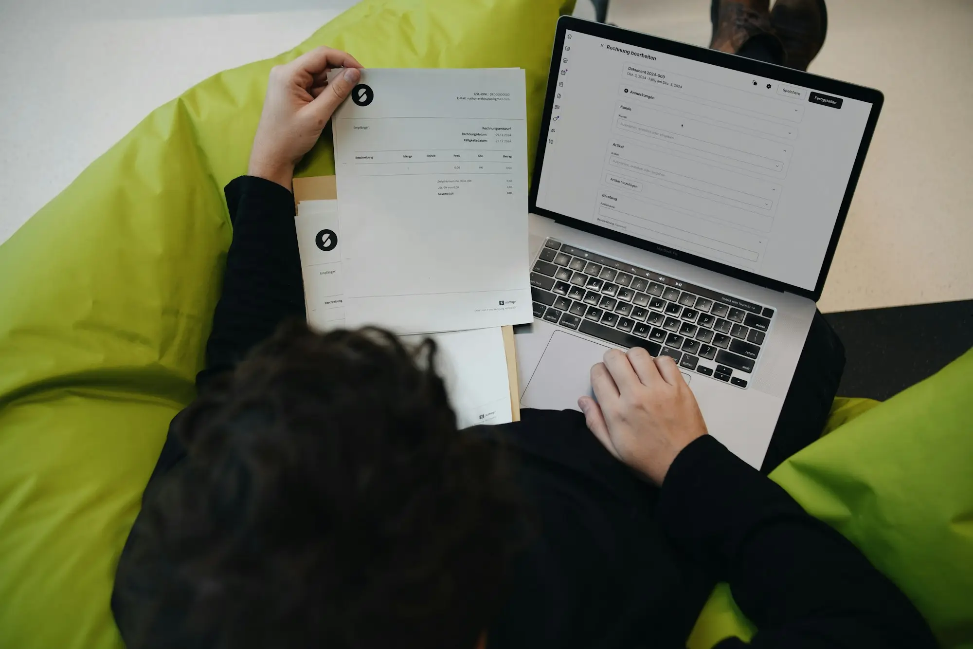 Business owner sorting receipts beside a laptop for BAS